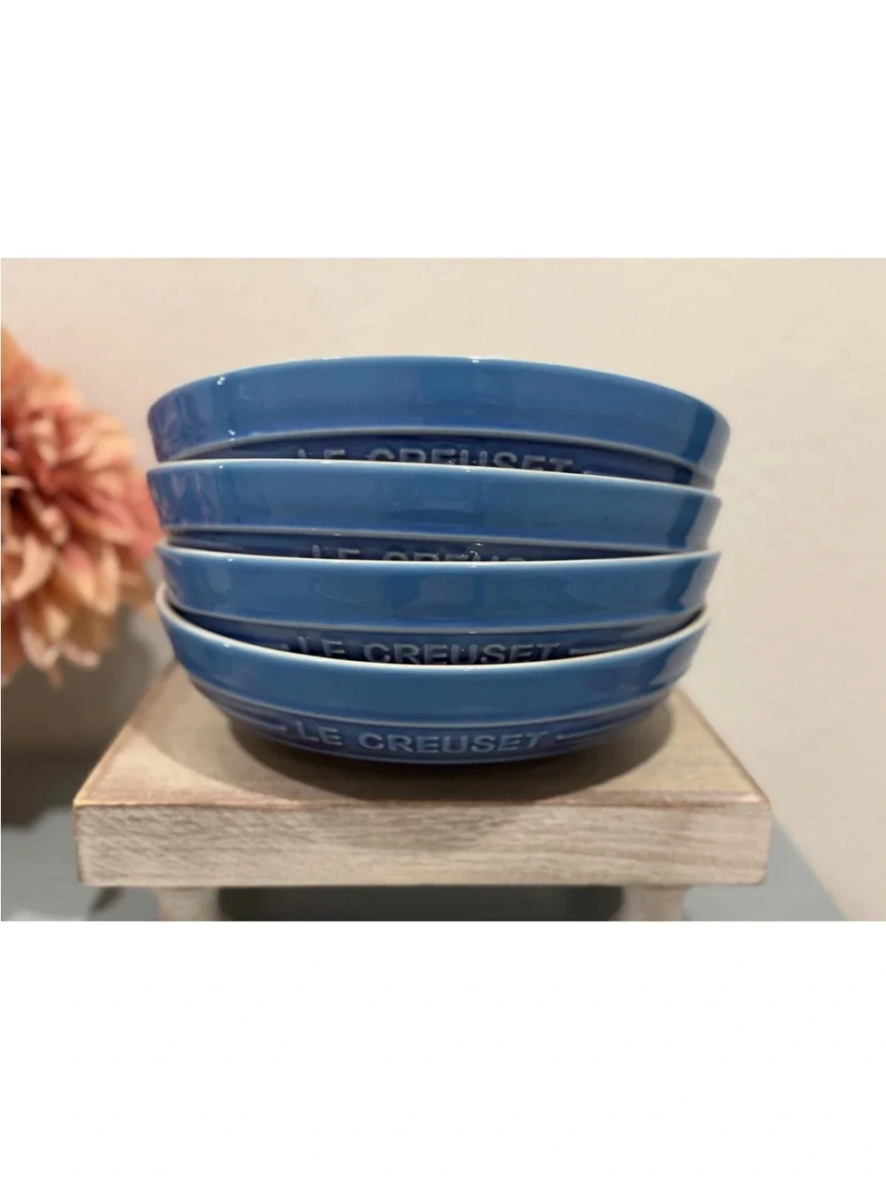 The product is a set of 4 Le Creuset deep round dish plates in a striking azure